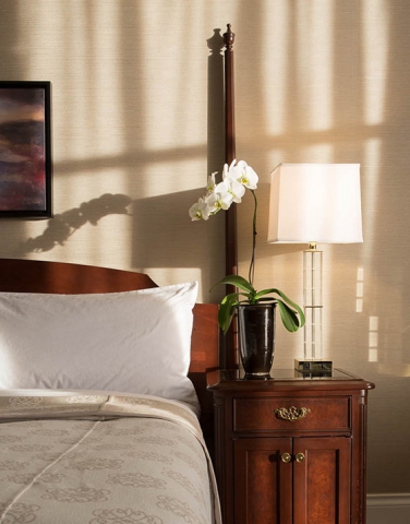 Scenic Bay Hotel Room bathed in sun, orchid on bedside table